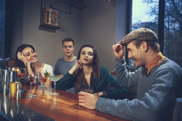 Foto von freudigen Freunden in der Bar oder in der Kneipe, die miteinander kommunizieren