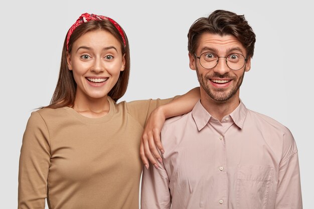 Foto von zwei freudigen Freundin, Freund unterstützen sich gegenseitig, haben zufriedenen Ausdruck