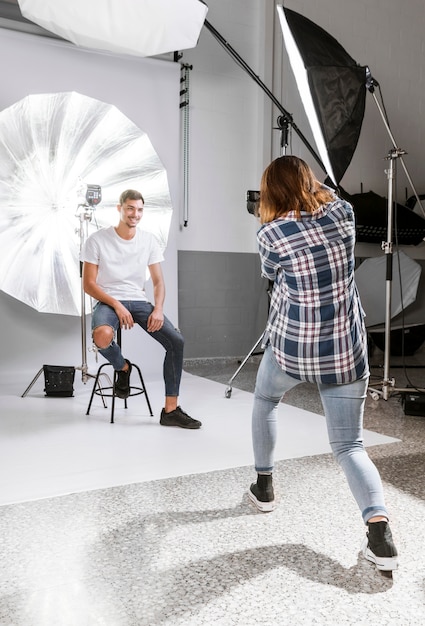 Fotograf, der ein Foto des männlichen Modells im Studio macht