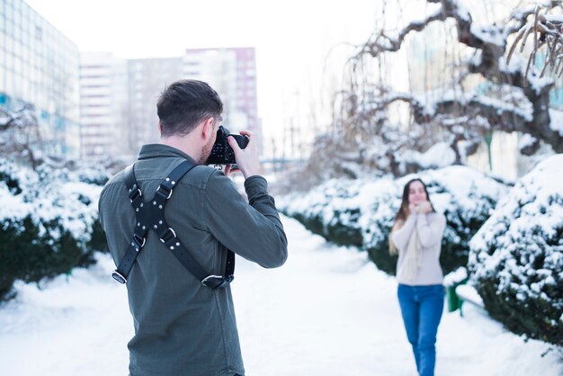 Fotograf, der Fotos des Modells in der schneebedeckten Straße macht