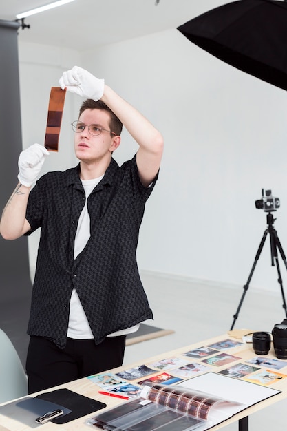 Fotograf, der in seinem Studio mit Fotostreifen arbeitet