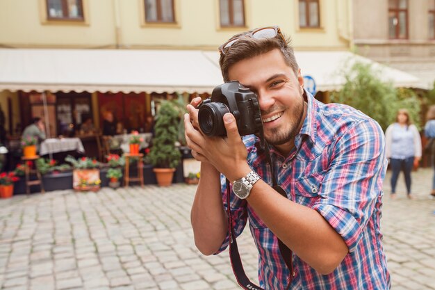 Fotograf des jungen Mannes, der Fotos macht, Fotos mit Digitalkamera zu ihren Freunden macht