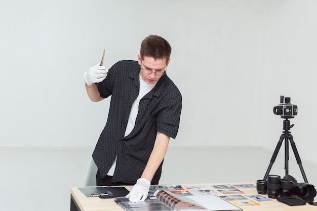 Fotograf in einem Studio, das Albumfoto betrachtet