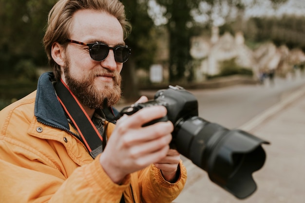 Fotograf Mann, der seine Fotos auf der Kamera ansieht