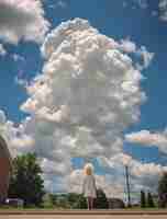 Kostenloses Foto fotorealistische wolken und eine frau im hintergrund