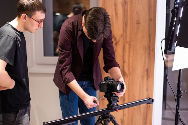 Kostenloses Foto fotosession zu hause. zwei fotografen, einer hält die kamera auf der horizontalen leiste