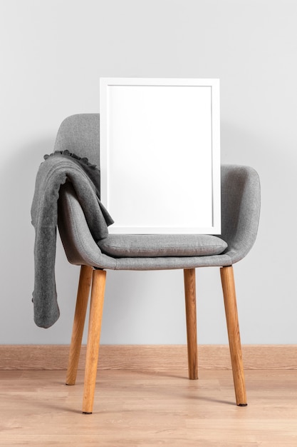 Kostenloses Foto frame mock up neben dem stuhl