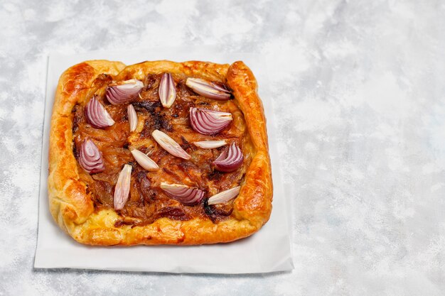 Französische Artzwiebeltorte galette mit Blätterteig und verschiedenen Zwiebelschalotten, rote, weiße, gelbe Zwiebeln, Draufsicht