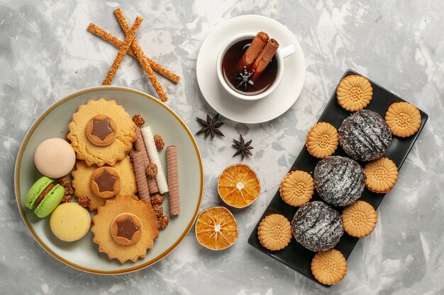 Französische Macarons der Draufsicht mit Schokoladenkuchen und Plätzchen auf weißer Kuchen-Kekszucker-Backkuchen des süßen Kuchen