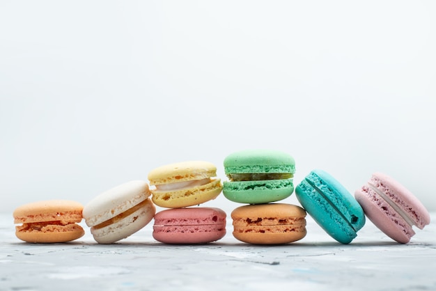 Französische Macarons mit Vorderansicht, köstlich und rund, geformt auf weißer Kuchenkeksfarbe