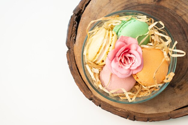 Französische Macarons von oben in der runden Glasplatte auf brauner hölzerner Kuchenkeksfarbe