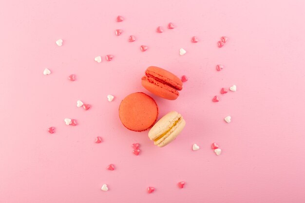 Französische Macarons von oben und rund auf dem rosa Tischkuchen-Kekszuckersüß