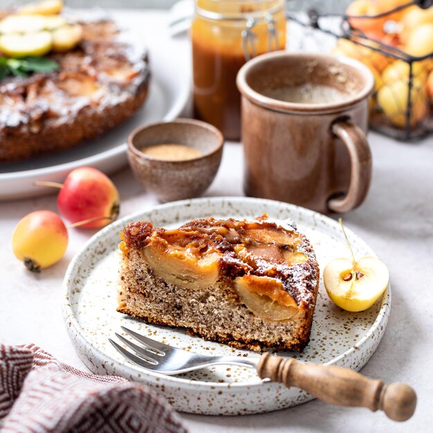 Französische süße Tarte Tatin Apfelkuchen auf den Kopf gestellt und frischer roter Apfel