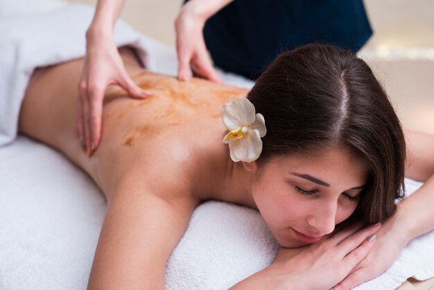 Frau am Badekurort eine Rückenmassage genießend