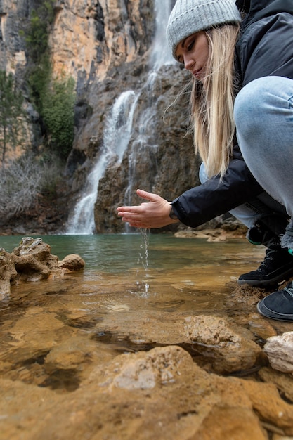 Frau am Fluss Hände waschen