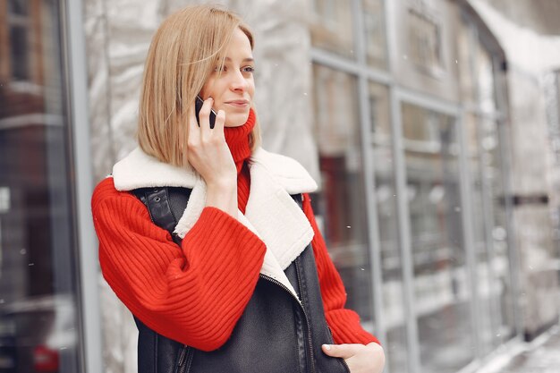 Frau am gebäude. neujahrsstimmung. dame in einer schwarzen jacke.