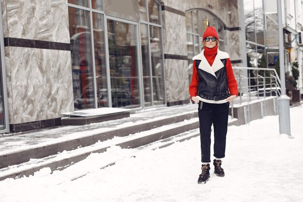 Frau am Gebäude. Neujahrsstimmung. Dame in einer schwarzen Jacke.