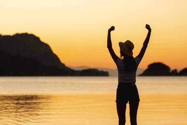 Frau am Sonnenuntergang am Ufer eines Sees