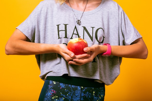 Frau an Ihrem lässigen Outfit, das Apfel hält