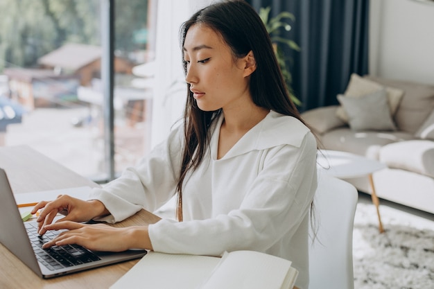 Frau arbeitet am Computer am Schreibtisch von zu Hause aus