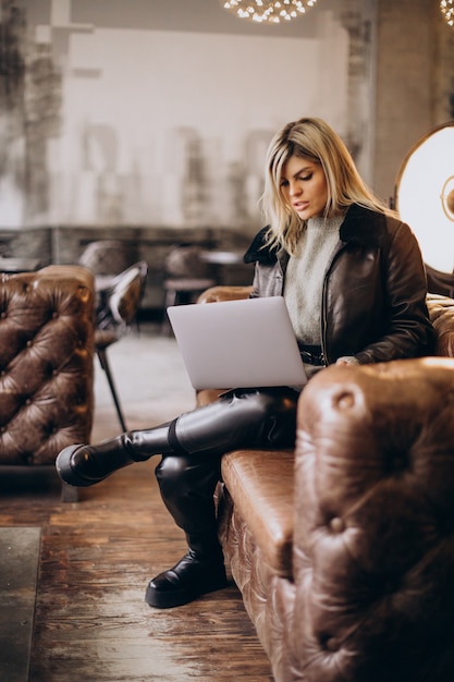 Frau arbeitet am Laptop in einem Café und sitzt Trainer