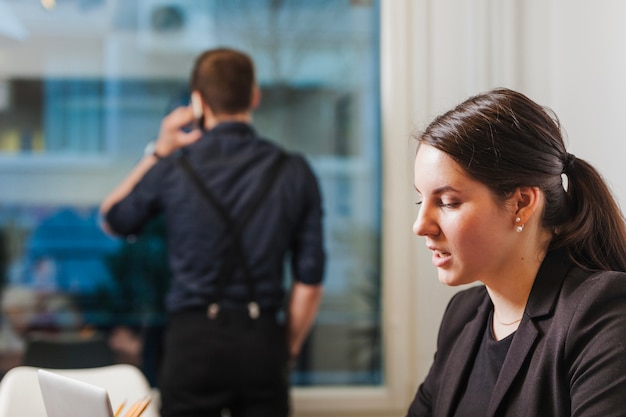 Kostenloses Foto frau arbeitet während mann sprechen telefon