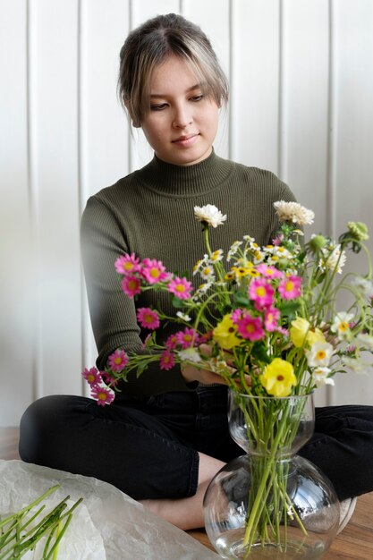 Kostenloses Foto frau arrangiert blumen in einer vase