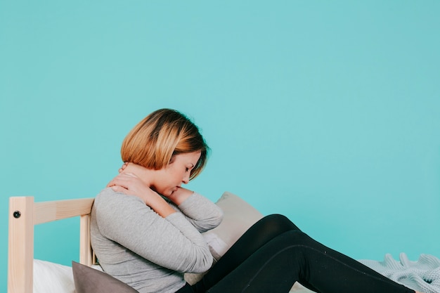 Kostenloses Foto frau auf dem bett mit nackenschmerzen