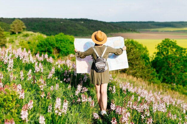 Frau auf dem Feld, das mit großer Karte schaut