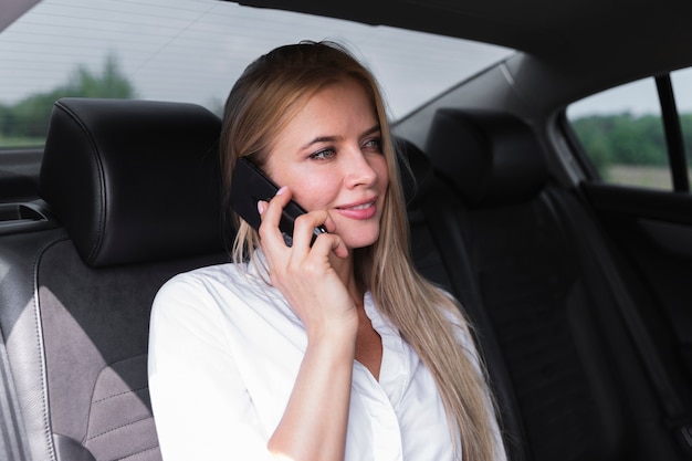 Frau auf dem Rücksitz sprechend am Telefon