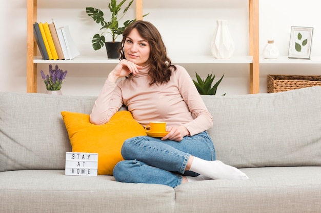 Frau auf der Couch, die Tee trinkt