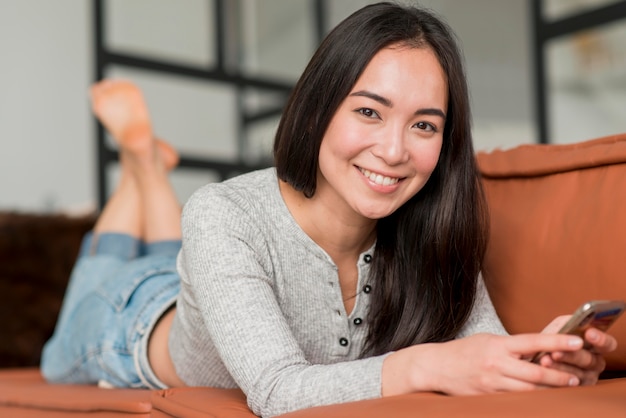 Kostenloses Foto frau auf der couch mit telefon