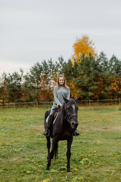 Frau auf einem Pferd auf Rancho. Reiten, Hobbyzeit. Konzept von Tieren und Menschen