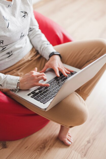 Frau auf Sessel tippen auf Laptop