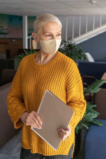 Frau bei der Arbeit, die eine medizinische Maske trägt