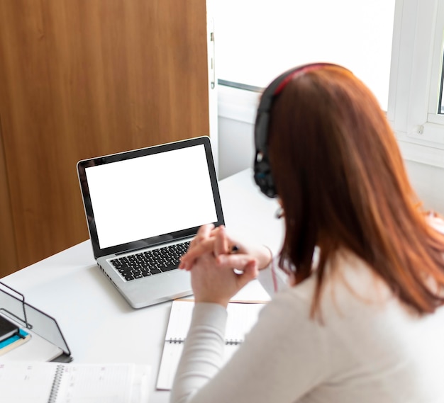 Frau bei der Arbeit, die Videoanruf auf Laptop hat