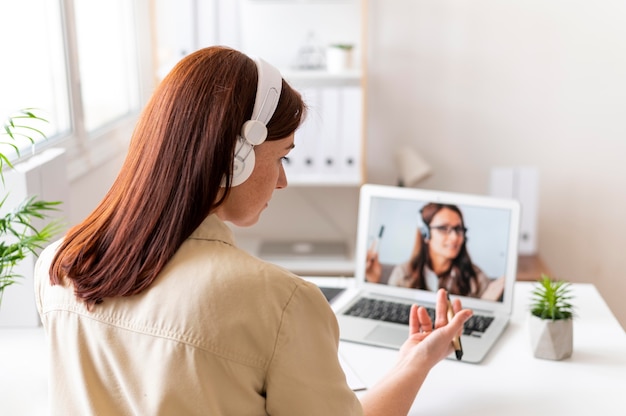 Frau bei der Arbeit, die Videoanruf auf Laptop hat