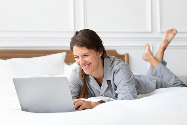 Frau bei einem Videoanruf im Bett