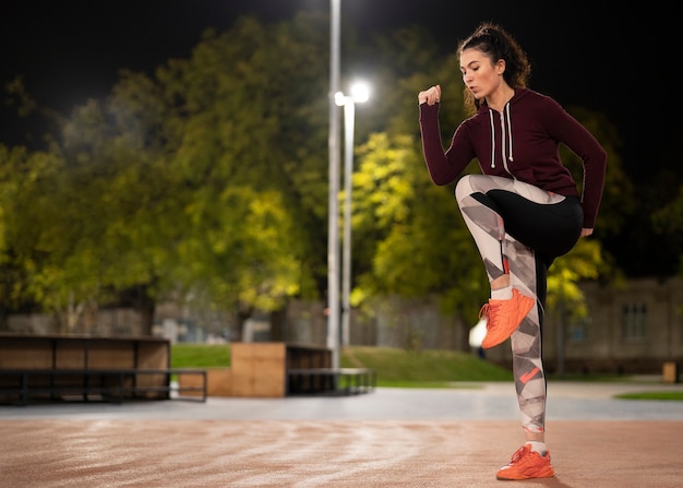 Frau beim Training in der Nacht voller Schuss