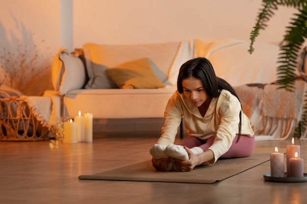 Kostenloses Foto frau beim yoga auf mattenseitenansicht