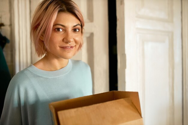 Frau bekommt ein Geschenk von der Post zu ihrem Haus.