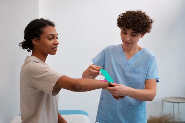 Kostenloses Foto frau bekommt in einem rehabilitationszentrum unterstützung für ihr handgelenk