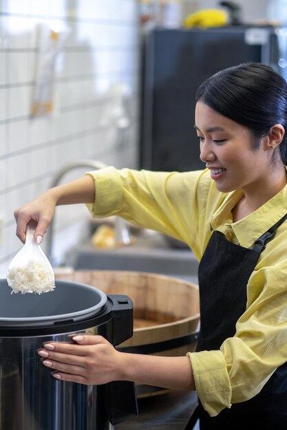 Frau bereitet Reis für Sushi in der Küche des Restaurants zu