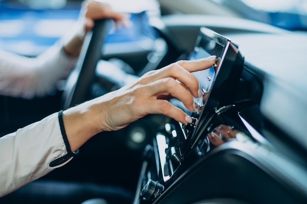 Frau berührt Bildschirm in ihrem Auto