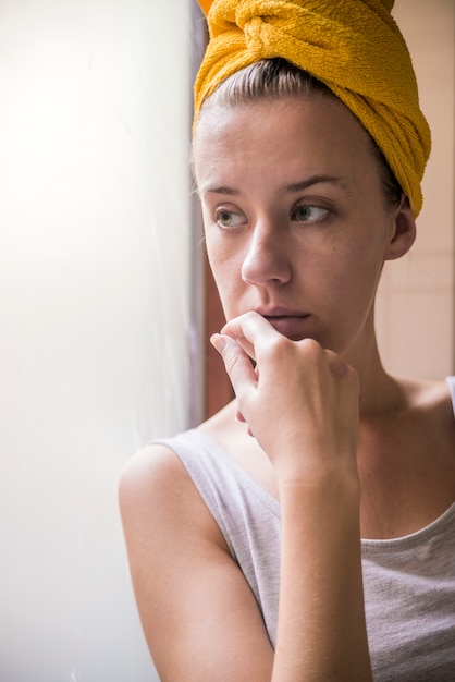 Frau deprimiert Serie. Trauriges Mädchen, das aus dem Fenster schaut, ist gefiltert.