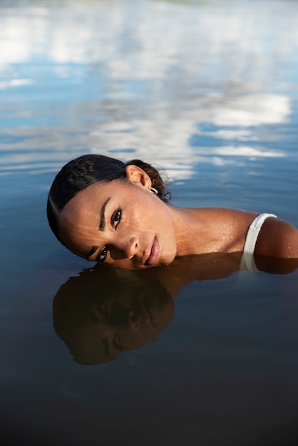 Kostenloses Foto frau des hohen winkels, die im see schwimmt