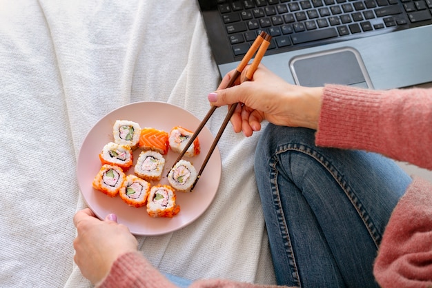 Kostenloses Foto frau des hohen winkels, die sushi hält