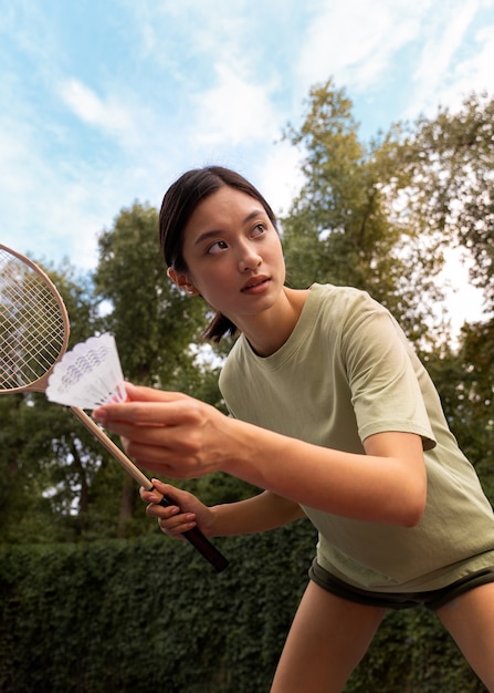 Kostenloses Foto frau des niedrigen winkels, die badminton spielt