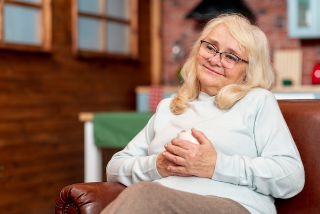 Frau des niedrigen Winkels zu Hause, die Tee trinkt