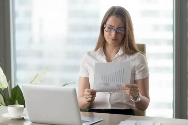 Frau, die abwärts Finanzindikatoren analysiert